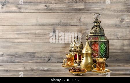 Oriental lantern, tea glasses and dates on wooden background Stock Photo