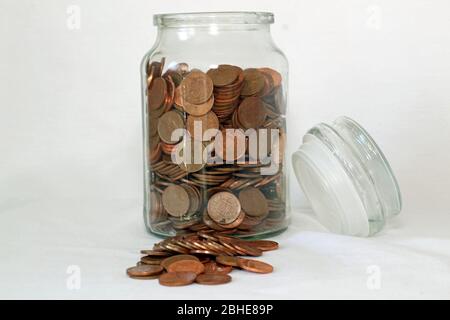 Glass savings jar with coins collection or savings for a rainy day Stock Photo