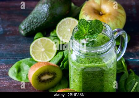 Healthy green smoothie on a dark wooden background. Vegetarian food concept, detox, fitness. Selective focus Stock Photo