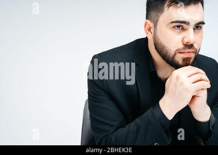 Young handsome man with beard and hand on chin thinking about question, pensive expression. thoughtful face. Doubt concept. Stock Photo