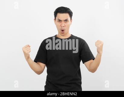 Excited young Asian man raising his fists with happy delighted face, celebrating success isolated on white background. Stock Photo