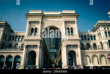 Milan, Italy, September 9, 2018: Gallery Vittorio Emanuele II Galleria famous luxury shopping mall facade and interior with fashion stores, glass dome, lamps in city centre on Piazza del Duomo square Stock Photo
