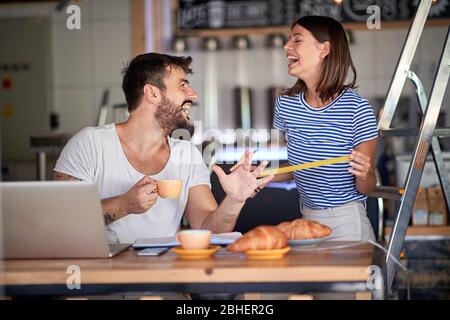 couple having breakfast and fun in coffee shop that they are about to open. starting business concept Stock Photo