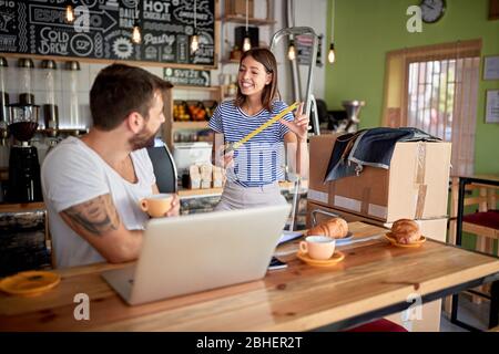 young couple having breakfast and fun in coffee shop that they are about to open. starting business Stock Photo