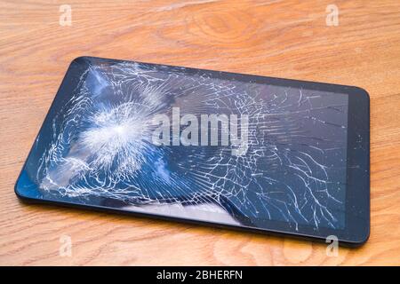 Tablet with cracked display on the desk Stock Photo