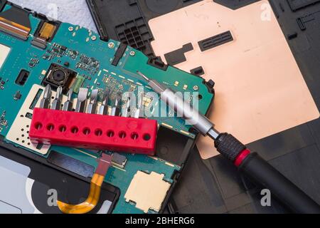 Close image of tablet repair process, screw set Stock Photo