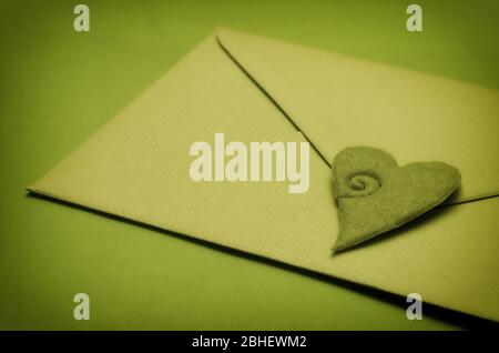 Green love letter envelope closed by an heart shaped decoration Stock Photo