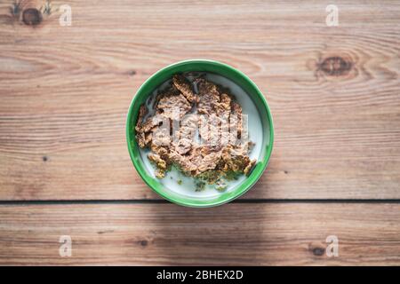 Top view of Healthy Whole-Grain Cereals Fitness meal. Milk and Cereals breakfast. Green bowl on wooden kitchen table background Stock Photo