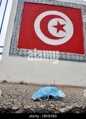 Tunis, Tunisia. 25th Apr, 2020. A discarded face mask lies on the ground during quarantine.At this time of the corona virus contagion, latex gloves and surgical masks are abandoned by people in parking lots, grassy fields, playgrounds and in the streets. Many with the potential to carry the Covid-19 virus inside. Credit: SOPA Images Limited/Alamy Live News Stock Photo