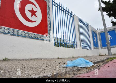 Tunis, Tunisia. 25th Apr, 2020. A discarded face mask lies on the ground during quarantine.At this time of the corona virus contagion, latex gloves and surgical masks are abandoned by people in parking lots, grassy fields, playgrounds and in the streets. Many with the potential to carry the Covid-19 virus inside. Credit: SOPA Images Limited/Alamy Live News Stock Photo