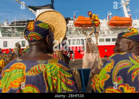 Cultural performance with dancers, a man on stilts and musicians in front of the MS Expedition in the port of Lome, Togo. Stock Photo