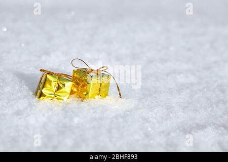 Christmas Gift Boxes lie on natural snow. Winter and New Year background with copy space. Snowy surface Stock Photo