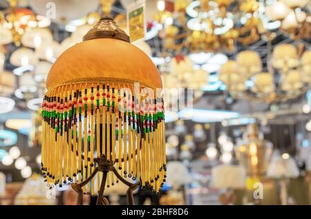 Yellow fabric floor lamp with pendants from of multi-colored beads. Stock Photo