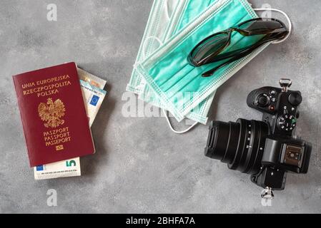 Medical mask and international Polish passport. On the front cover text says 'European Union, Poland, Passport' in English language. Travel concept, t Stock Photo