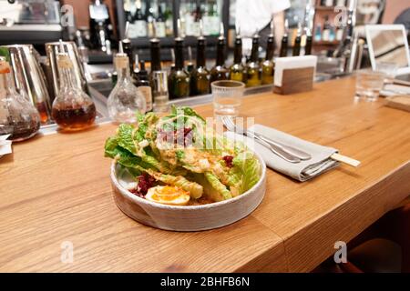 Caesar salad cooked in Asian way served on bar counter Stock Photo