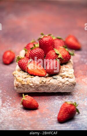 Red, fresh and tasty strawberries on a stone and a red background Stock Photo