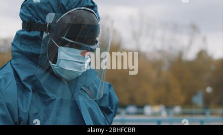 Man wearing NBC personal protective equipment ppe suit, mask, goggles and face shield. Preventing coronavirus spread Stock Photo