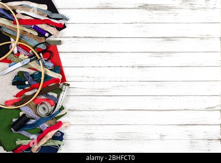 quilting, embroidery and sewing tools on the white wooden background. patchwork knife, scissors, lined cutting mat, self-locking, threads, measuring t Stock Photo