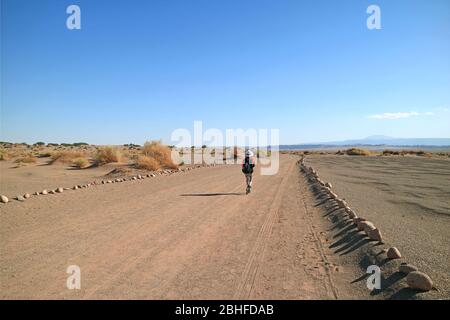 Female Traveler Walking on the Desert Road of Aldea de Tulor Archaeological Site, Atacama Desert, Northern Chile, South America Stock Photo