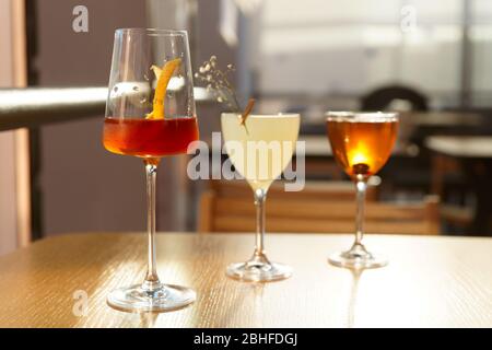 Three simple looking cocktails on restaurant table, sunlight Stock Photo