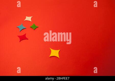 There are 5 rectangular colored stars on red cardboard. For background, with place for text Stock Photo