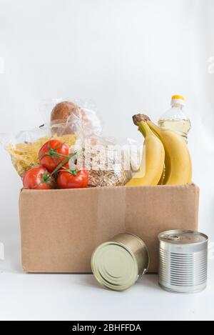 Various canned food, pasta, rice, oil, bananas  and raw cereal grains on a table  with copy space Stock Photo