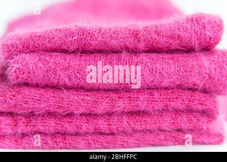 Pattern of pink knitted sweater  closeup. Handmade merino wool product. A stack of folded clothes Stock Photo