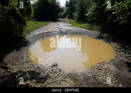 A large puddle on a dirt country road. Stock Photo