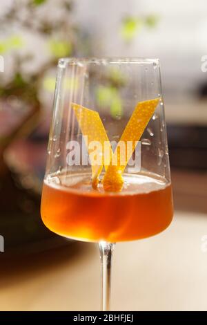 Japanese style cocktail with lemon zest in wineglass, sunlight Stock Photo