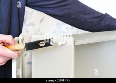 A man collects a drawer for a chest of drawers. DIY furniture assembly. Order furniture home in quarantine. Stock Photo