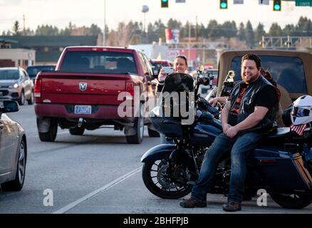 Kalispell, Montana, USA. 24th Apr, 2020. Motorcyclists along Main Street in downtown Kalispell watch Kruise Kalispell. For the 3rd Friday evening in a row Kruise Kalispell has held this event in spite of Montana's Stay At Home Order by the Governor due to the Covid-19 pandemic . Hundred's of people in cars, on motorcycles and on foot gather for the events as a way to have public gatherings. Credit: Kent Meireis/ZUMA Wire/Alamy Live News Stock Photo