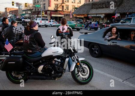 Kalispell, Montana, USA. 24th Apr, 2020. Motorcyclists along Main Street in downtown Kalispell watch Kruise Kalispell. For the 3rd Friday evening in a row Kruise Kalispell has held this event in spite of Montana's Stay At Home Order by the Governor due to the Covid-19 pandemic . Hundred's of people in cars, on motorcycles and on foot gather for the events as a way to have public gatherings. Credit: Kent Meireis/ZUMA Wire/Alamy Live News Stock Photo