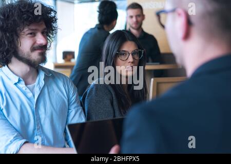 Work colleagues discussing new marketing strategies during a coffee break Stock Photo