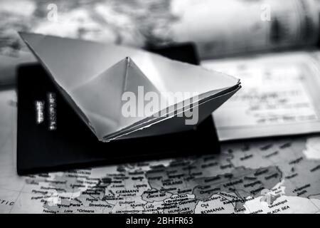 Conceptual shot of a paper boat and a passport on European Political map. The concept for planing a European summer vacation trip. Stock Photo