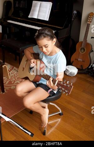 Austin Texas USA, 2012: 10-year-old Japanese-American girl practices playing the guitar at home. ©Marjorie Kamys Cotera/Daemmrich Photography Stock Photo