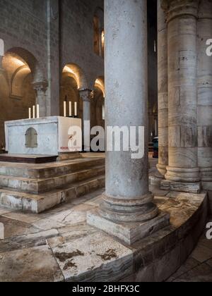 Montalcino, Italy - April 22, 2019: Detail of the columns arranged in a circle around the altar of an ancient medieval church. Stock Photo