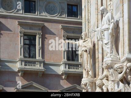 Detail of the Milan Cathedral with statues against the building of Galleria Vittorio Emanuele II Stock Photo