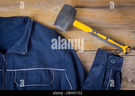 Work clothes and mallet on old wooden background Stock Photo