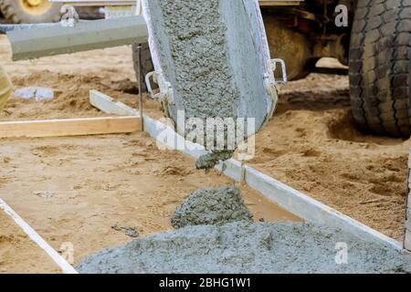 Construction workers mixer truck cement during pouring sidewalk to residential street Stock Photo