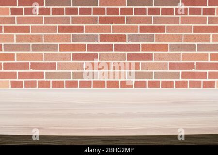 Wood table next to a rustic red brick wall. Stock Photo