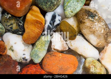 close up of a bunch of small naturally polished stones found in the Oregon coast in a variety of bright colors and shapes Stock Photo