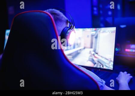 Professional cyber video gamer studio room with personal computer for stream in neon color blur background. Soft focus Stock Photo