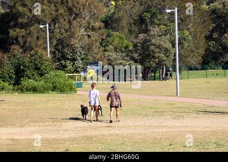 Australian male and female walking their dogs in the park during covid-19 lockdown in Sydney,Australia Stock Photo