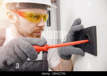 Electrician builder install working switches and sockets black color loft style Stock Photo