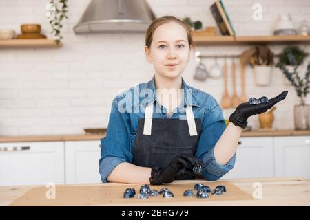 Portrait of young woman businesswoman holding cook of chocolates on kitchen background. Concept small business pastry chef home Stock Photo