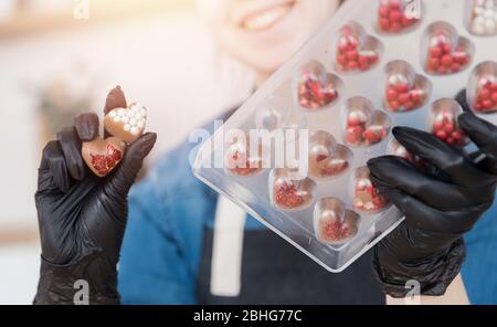 Confectioner girl holds form for candy made of Belgian chocolate Stock Photo