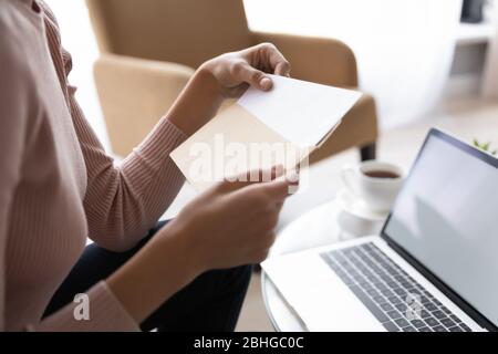 Close up side view young woman holding craft paper envelope. Stock Photo
