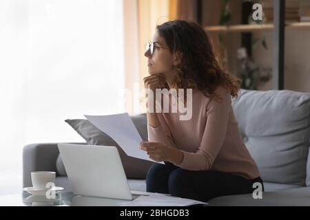 Distracted from work or study young pretty woman looking away. Stock Photo