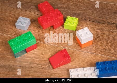 view on colorful toy bricks on a brown wooden background. Toys in the table Stock Photo