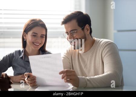 Young successful couple, man and woman reading business document. Stock Photo